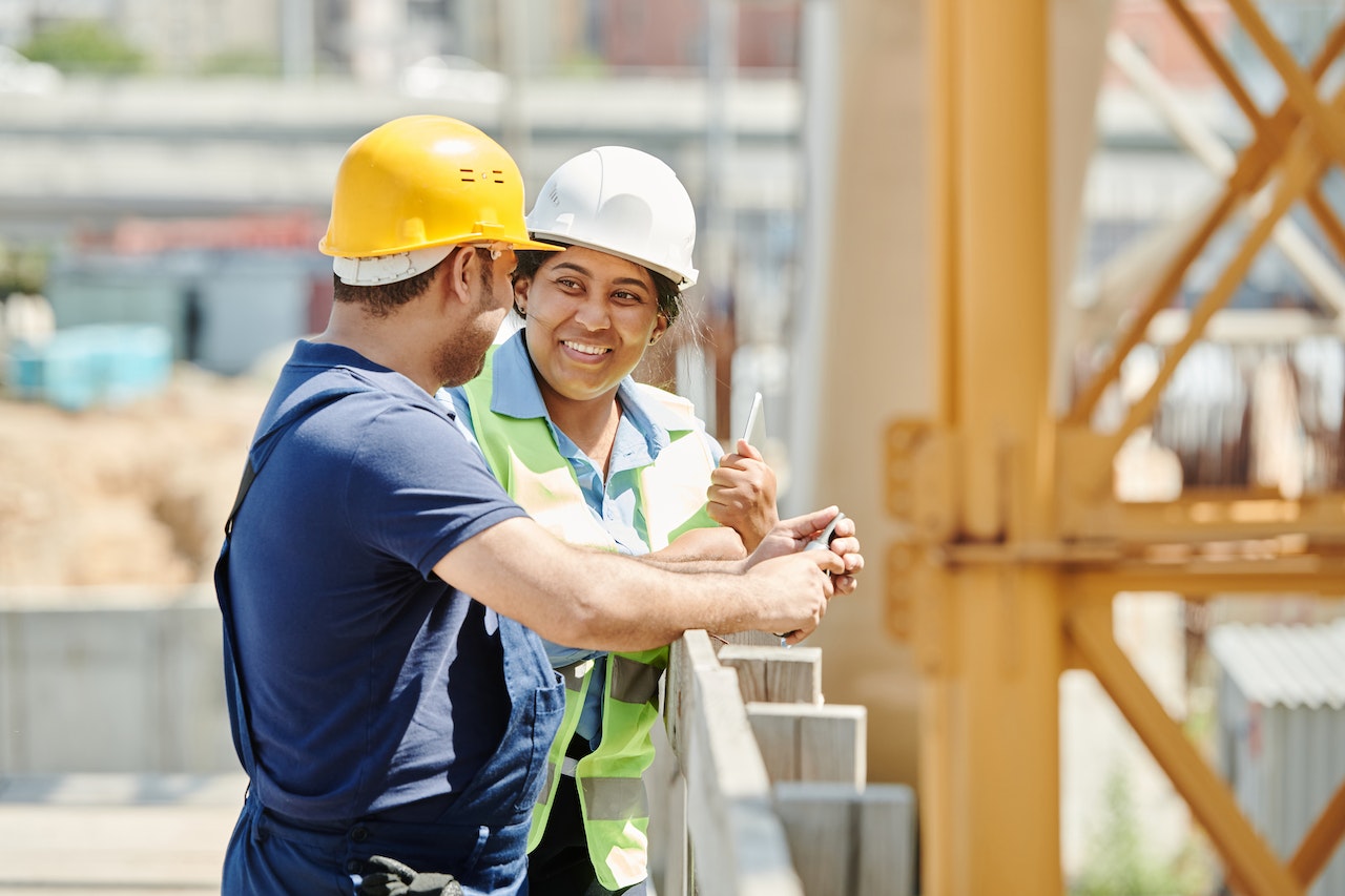 Two construction workers in hard hats and hi-vis on a jobsite
