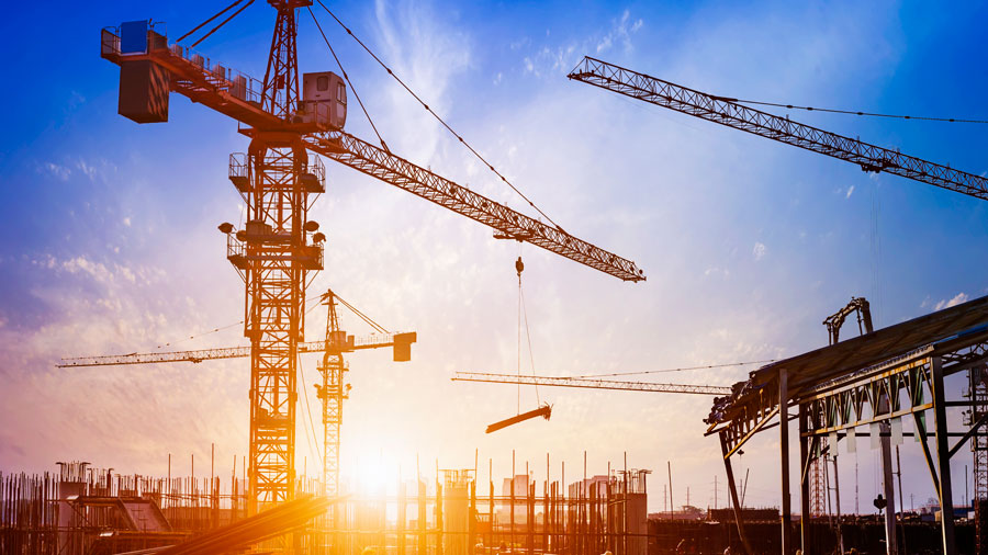 Construction site with tower cranes at sunset under OSHA heat exposure limits