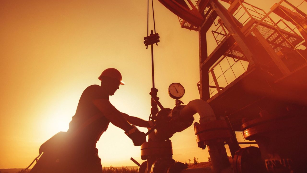 Oil and gas worker laboring in extreme heat at sunset during a multi-day heat wave